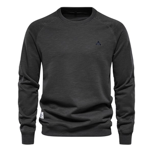 Close-up of charcoal grey sweatshirt fabric texture with geometric logo and crew neckline