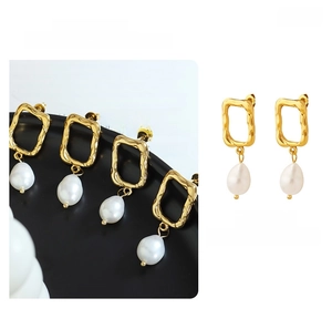 Macro detail of gold-plated geometric earrings with baroque teardrop pearls
