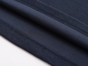 Macro detail of navy blue knit polo shirt showing premium stitching on hem and cuffs