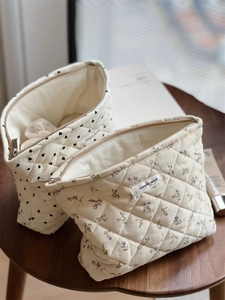 Detailed macro view of quilted corduroy makeup bags with floral and heart patterns