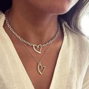 Detailed view of layered silver heart pendants on bead and cable chains