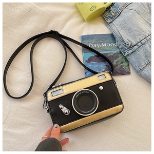 Detail view of a vintage camera-shaped crossbody bag with stylish gold color blocking