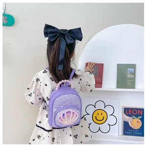 Detail of purple sequin girls backpack featuring a shell patch and pearl top handle