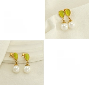 Détail macro de boucles d'oreilles dorées avec opale verte et perle blanche ronde