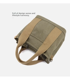 Detail of army green canvas tote bag with thick khaki webbing and metal D-ring attachment