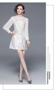 Close-up of white vintage jacquard dress with intricate embroidery and sheer chiffon sleeves