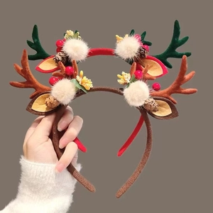 Plush Christmas reindeer antler headband with festive pine cones and berries for holiday decor