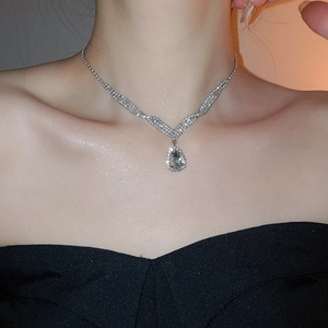 Close-up of a silver V-shaped crystal necklace featuring a teardrop pendant for elegant evening wear