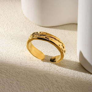 Detail of 18K gold adjustable ring featuring irregular liquid texture and hammered design