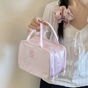 Borsa cosmetica in raso rosa con ricamo a fiocco e comoda maniglia per trasporto