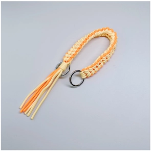 Detailed macro view of yellow and orange hand-woven shoulder strap with metal rings