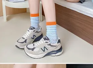 Close-up of mesh sneakers with N logo and orange plaid socks for a sporty look