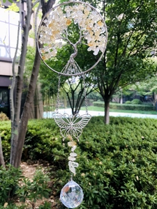 Detail of Tree of Life suncatcher with yellow stones and crystal ball hanging in garden