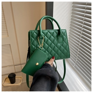 Close-up of a green quilted handbag with a matching small coin purse and metal chain