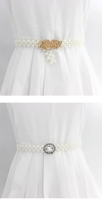Détail d'une chaîne de taille en perles avec boucle fleur dorée et fermoir en strass