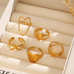 Detail von fünf 18k vergoldeten Edelstahl-Herzringen in einer beigen Schmuckbox