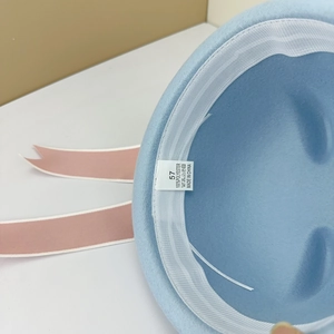 Close-up of sailor hat interior showing 100% polyester label and size 57 tag