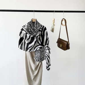 Close-up of zebra and leopard print scarf with smooth silk-like texture in black and white