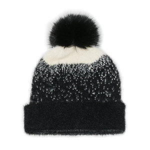 Close-up of black and white knit beanie with soft faux fur pom and brushed mohair texture