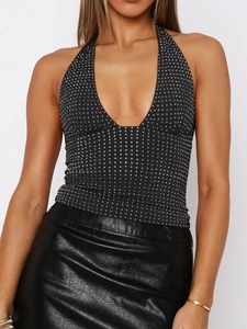 Detail of sexy Y2K black halter top with silver polka dot pattern on model