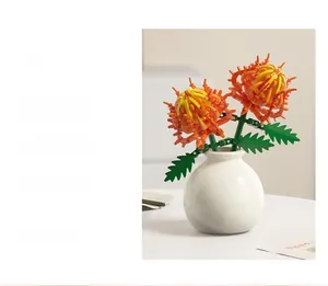 Detail of yellow chrysanthemum building blocks with green leaves in a white ceramic vase