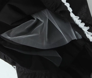 Détail de la doublure en maille blanche et du tissu noir de la robe de princesse