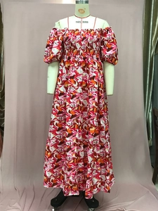 Detalle del estampado floral bohemio en vestido maxi de verano con hombros al aire
