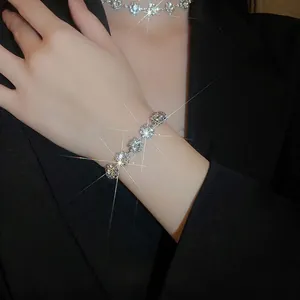 Elegant silver jewelry set with sparkling floral crystals worn on a black blazer
