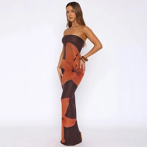 Détail de la robe longue bustier ajustée avec imprimés de lys orange sur fond marron