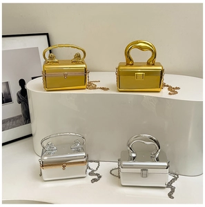 Close-up of luxury gold and silver acrylic box evening bags with lion head handle and chain