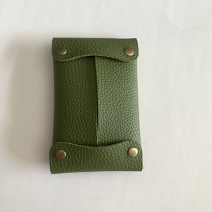 Close-up of green lychee pattern leather tissue pouch with bronze metal snaps