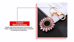 Close-up of sparkling pink crystal sunflower keychain with center pearl and golden ring