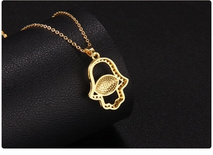 Macro back view of the golden Hamsa Hand pendant necklace with detailed texture on leather