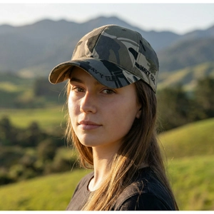 Detail of jungle camouflage baseball cap with Navy Seal embroidery in outdoor setting
