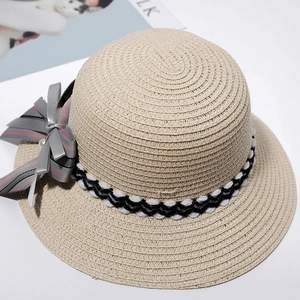 Detail of light beige straw hat featuring grey-pink striped bow and pearl accent