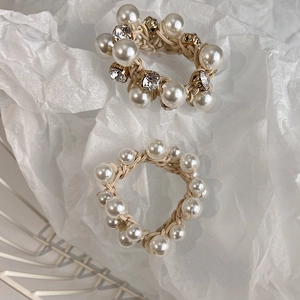 Close-up of minimalist white pearl elastic hair bands with sparkling rhinestone accents