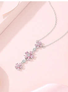 Close-up of S925 silver tassel necklace featuring pink plum blossom gemstone pendants