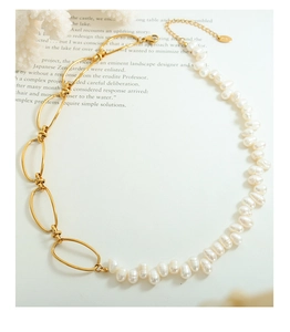 Detail view of the gold chain link and natural freshwater pearl necklace stitching