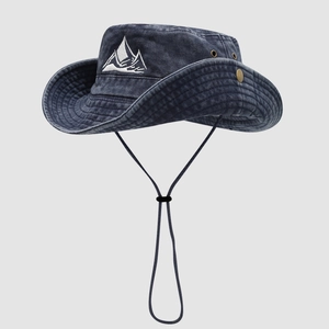 Detailed view of the mountain peak embroidery and metal side vents on a navy denim hat