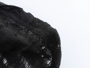 Gros plan détaillé sur la texture de la dentelle noire et l'ourlet de la robe moulante