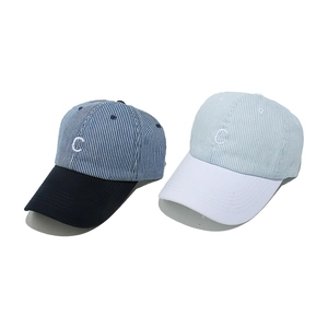Gros plan de la broderie détaillée lettre C sur casquettes rayées en coton