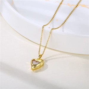 Collier cœur doré avec pendentif en zircon clair sur un plateau texturé élégant