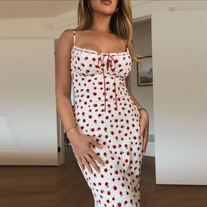 Detalle del borde de encaje blanco y lazo rojo en el vestido de verano con flores