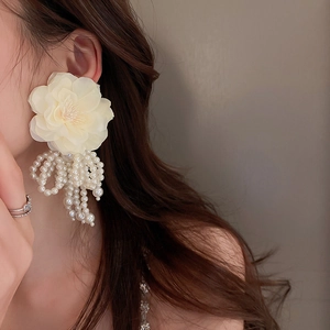 Elegant beige fabric flower earrings with white imitation pearl tassels worn by model
