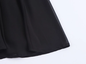 Dettaglio ravvicinato dell'orlo in chiffon nero e delle cuciture professionali del vestito