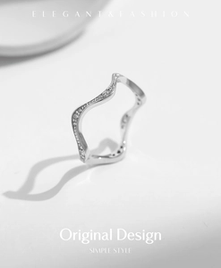 Detail of S925 sterling silver wavy ring with small embedded sparkling gemstones
