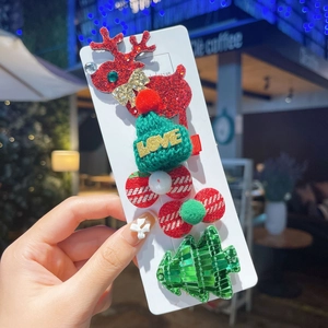 Detailed view of 5-piece Christmas hair clips including reindeer, hat, and sequined tree