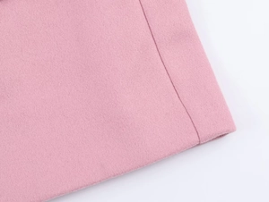 Detail of pink wool fabric texture and high-quality stitching on an oversized blazer