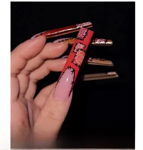 Dettaglio ravvicinato di unghie lunghe ballerina con design patch rosso e rosa e glitter