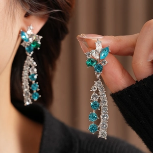 Detail of luxury vintage flower tassel earrings with blue and green rhinestones